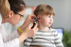 an audiologist examining a young girl's ear
