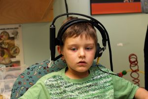Young boy wearing headphones while having his hearing tested