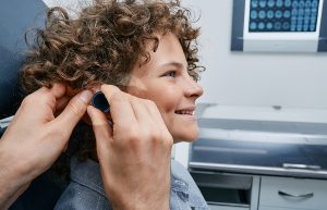 Pediatric audiologist testing a curly-haired child's hearing